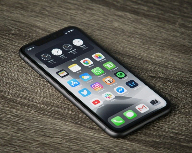 Smartphone appoggiato su un tavolo di legno con la schermata delle applicazioni